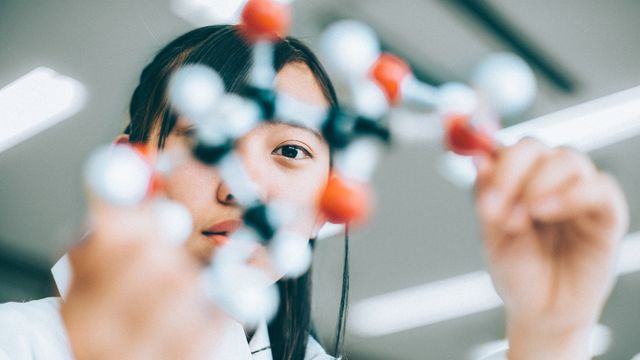 Scientist examining a molecular model, illustrating research focus in metabolomics. 