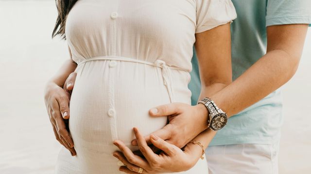 Partner holding a pregnant belly, symbolizing pregnancy gut microbiome and maternal health. 