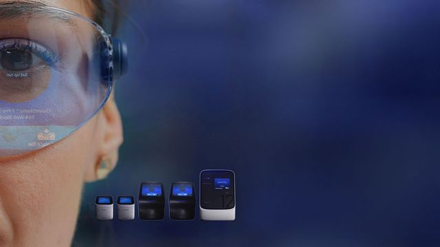 Close-up of a scientist wearing protective goggles with a reflection of lab equipment, alongside a set of PCR machines on a dark blue background 